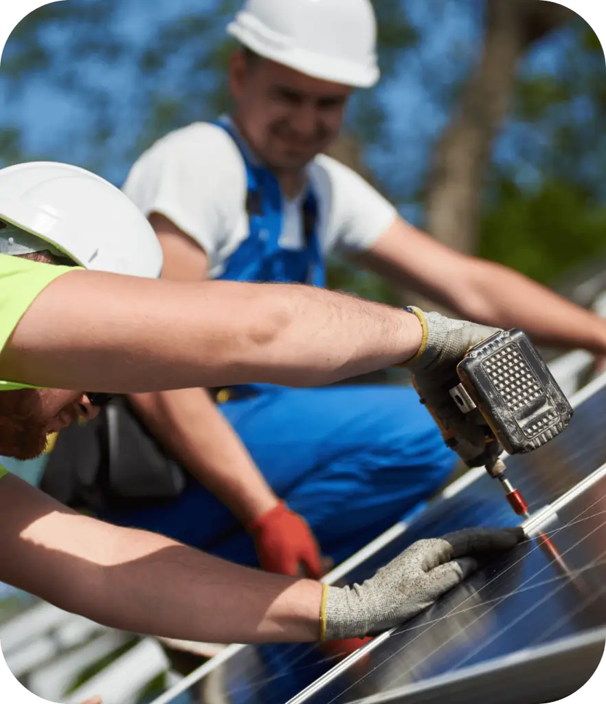 Équipe de techniciens installant des panneaux solaires photovoltaïques avec visseuse